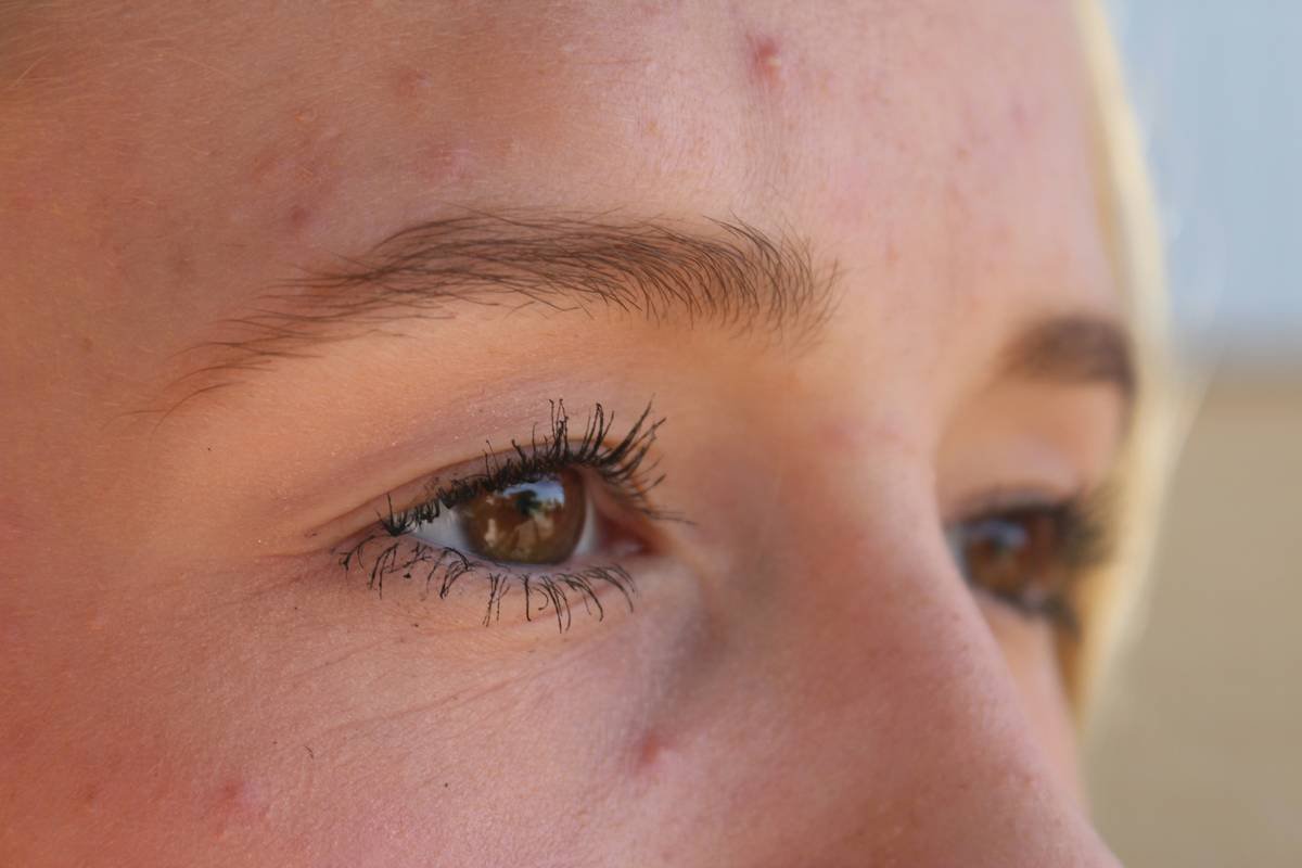 Side-by-side comparison showing brows filled with pencil (harsh lines) vs. tinted cosmetic powder (soft, hair-like strokes)